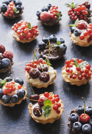 Sweet homemade mini tart cake with pudding and berry fruits,selective focusの写真素材