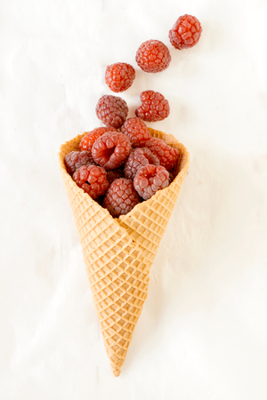 Fresh raspberries in the ice cream cone,selective focusの写真素材