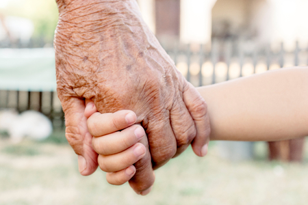 Grandchild holding grandparent for the hand,selective focusの写真素材