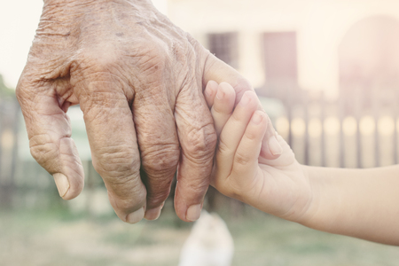 Little child holding her grandparent for hand,selective focusの写真素材