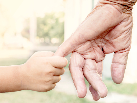 Young child holding her grandparent for the hand,selective focusの写真素材