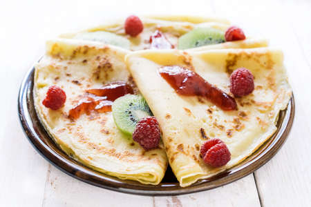 Close up to sweet homemade pancakes stuffed with raspberries jam.の写真素材