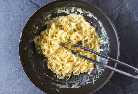 Spaghetti in pan with cheese sauceの写真素材