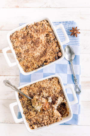 Sweet homemade apple crumble from above on white wooden backgroundの写真素材