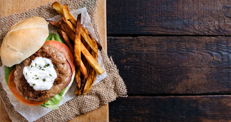Beef burger wiith cheese cream and french fries on wooden background with blank spaceの写真素材