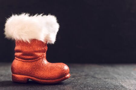 Empty red boots of Santa on dark background with blank spaceの写真素材