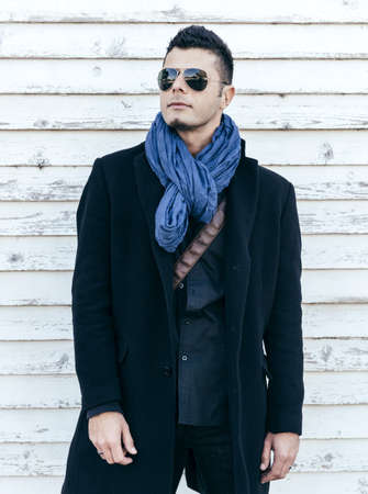 Photo with handsome man in coat on white wooden background,selective focusの写真素材