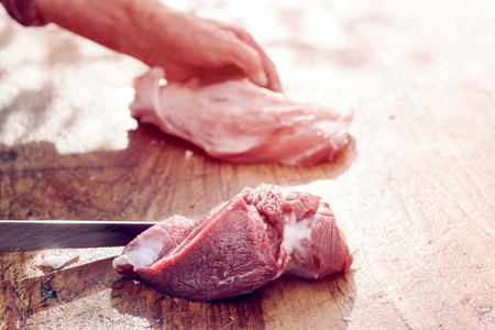 Butcher slicing raw pork fillet,selective focusの写真素材