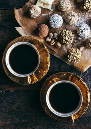 Dark coffee and sweet homemade pralines on wooden backgroundの写真素材