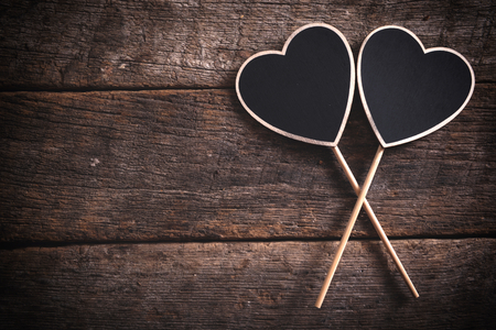 Couple of heart shape chalkboard on wooden background with blank spaceの写真素材