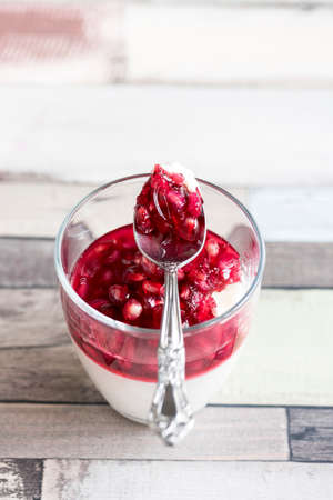 Panna Cotta with pomegranate in glass,selective focus