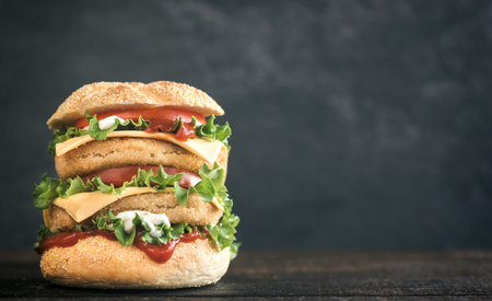 Juicy double fish burger on wooden background with blank spaceの写真素材