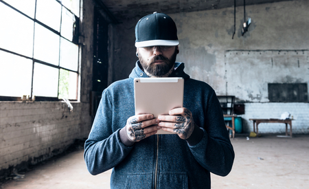 Tattooed man using tablet compiuter,selective focus