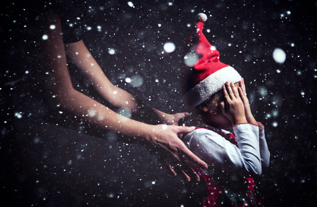 Little child holding hands on her head and waithing for Christmas presentの写真素材