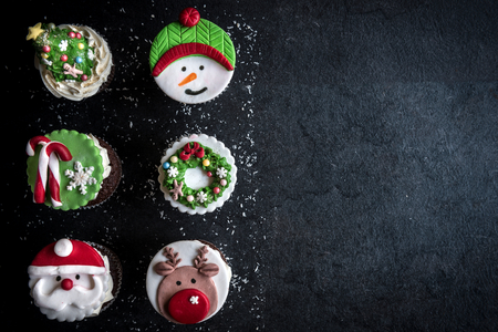 Sweet cup cakes with Christmas decoration on dark background,blank spaceの写真素材