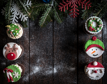 Christmas cup cakes served on the wooden table with blank spaceの写真素材