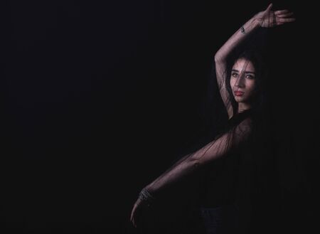 Female posing in the studio on dark backgroundの写真素材