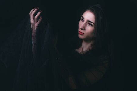 Woman portrait in low key technique on dark backgroundの写真素材