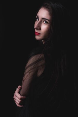 Female on the dark background in low keyの写真素材