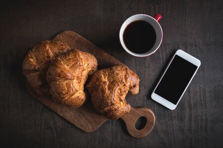 French croissants with cup of coffee and smart phone,selective focusの写真素材