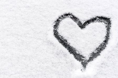 Drawed heart on the snow background with blank spaceの写真素材