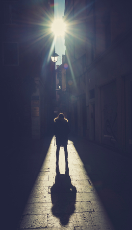 Silhouette of woman with big shadow on the streetの写真素材