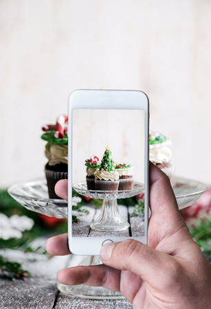 Man photographing sweet cup cakesの写真素材