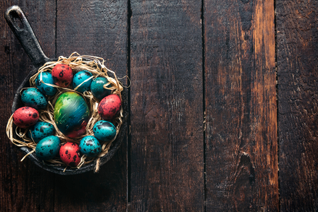 Easter eggs in the nest on wooden background with blank spaceの写真素材
