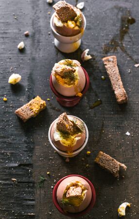 Soft boiled eggs with grilled toast bread on wooden background