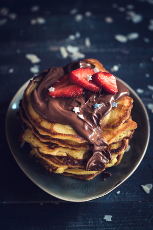 Sweet homemade pancakes with chocolate and strawberries on the topの写真素材