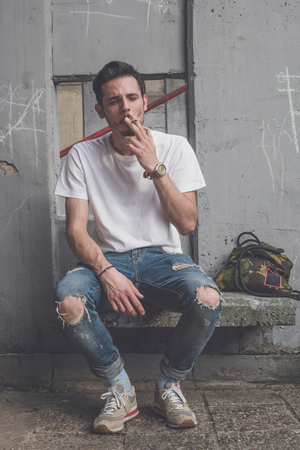 Man smocking cigarette and posing outdoorの写真素材