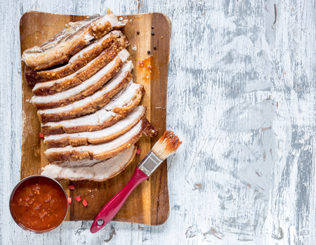 Split roasted and sliced pork belly on wooden background with blank spaceの写真素材