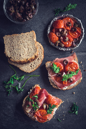 Toast sandwiches with grilled tomatoes,cheese and prosciuttoの写真素材