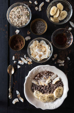 Served healthy breakfast with oatmeal and ingrediants on the wooden tableの写真素材