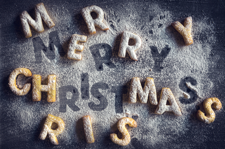 Merry Christmas sign with homemade cookies on dark background の写真素材