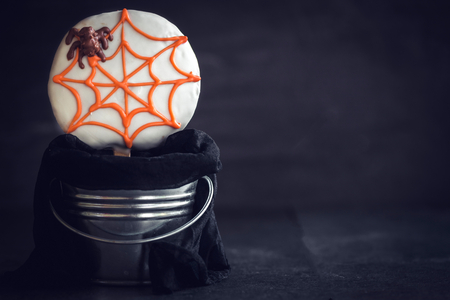 Spider cookie lollipop in basket on dark background with blank space の写真素材