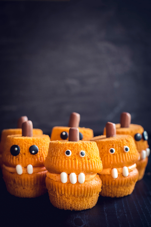 Group of scary pumpkin cup cakes on dark background の写真素材