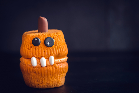 Scary halloween cupcake served on dark background with blank spaceの写真素材