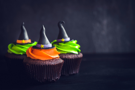Scary witch hat cupcakes on dark background with blank spaceの写真素材