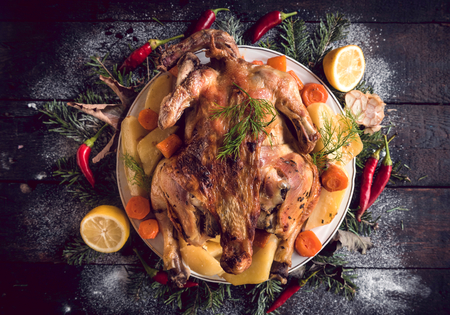 Whole roasted turkey with baked potatoes served on the plateの写真素材