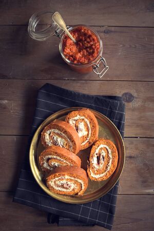Ajvar rolls with cheese and ham on wooden background,high angleの写真素材