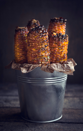 Grilled with corn with spices in the metal basketの写真素材