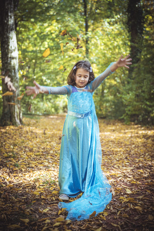 Little girl playing with leaves in the wood,selective focusの写真素材