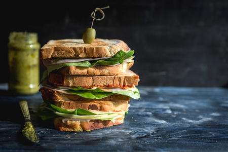Toast sandwich with pesto and ham on wooden background with blank space,selective focus の写真素材