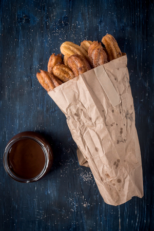 Churros packed and chocolate cream on the tableの写真素材