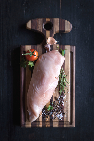 Raw chicken file on wooden cutting boardの写真素材