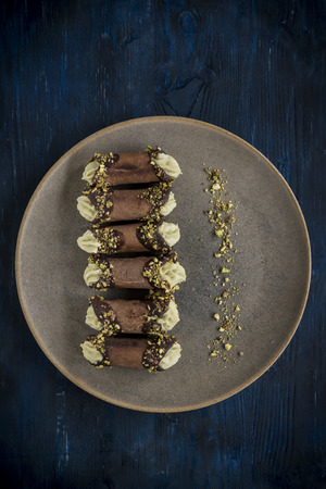 Traditional Italian dessert cannoli with pistachios served on the plate,selective focus の写真素材