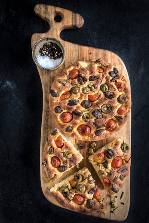 Homemade Italian Focaccia served on big wooden board の写真素材
