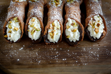 Traditional Italian dessert cannoli with sliced pistachios,selective focus の写真素材