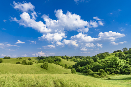 Beautiful green hills with cloudscape and blue skyの写真素材